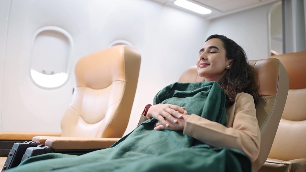 Young,Hispanic,Latino,Woman,Passenger,Sleeping,On,Seat,With,Blanket long flight